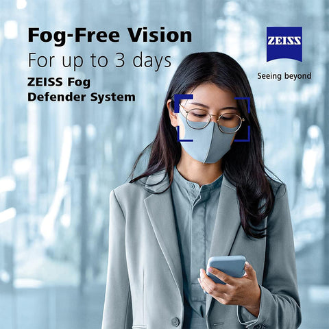 A person with a face mask and glasses uses a smartphone. Text states, Enjoy fog-free vision for up to 3 days with the ZEISS Fog Defender System Anti-Fog Spray for Glasses, alongside Seeing beyond logos. The background is blurred.