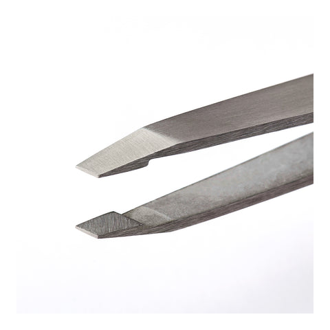 Close-up of RevitaLash Precision Tweezer with slanted tips against a white background. The slightly open, professional-grade tweezers by RevitaLash are designed for precise tasks like grooming brows or gripping small objects.