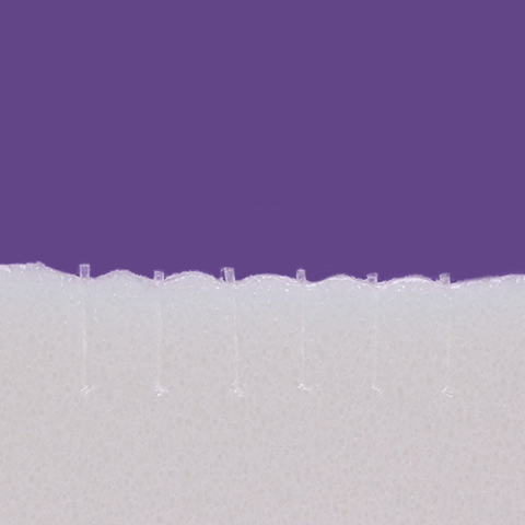 A close-up of a white foam texture with small spikes on a solid purple background resembles the detailed surface of Lacrivera VeraC7 Collagen Plugs, used in 7-day dry eye therapy.