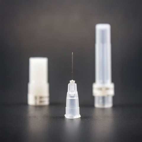 A close-up of MedPharma USAs 33g x 1/2 disposable needle, with dual protective caps, stands upright against a dark background. The focused needle is centered, while the blurred caps softly blend into the backdrop, highlighting its suitability for various medical applications.